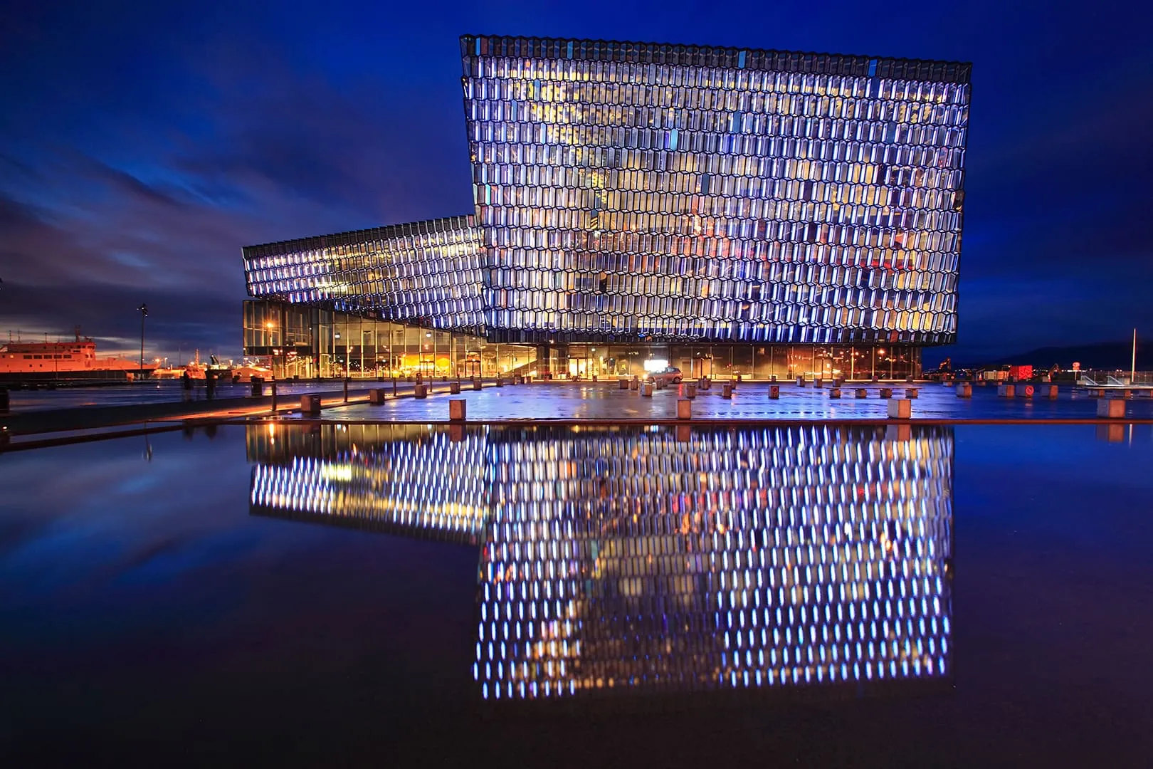 อาคารกระจก Harpa เปิดไฟยามค่ำคืนสะท้อนบนผิวน้ำ
